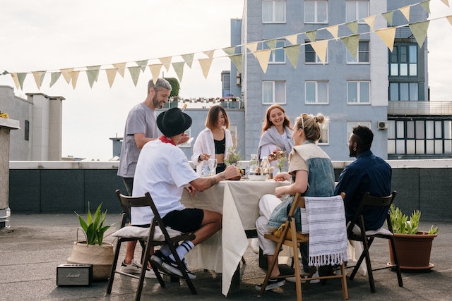 a group of people on an apartment rooftop having a dinner party
